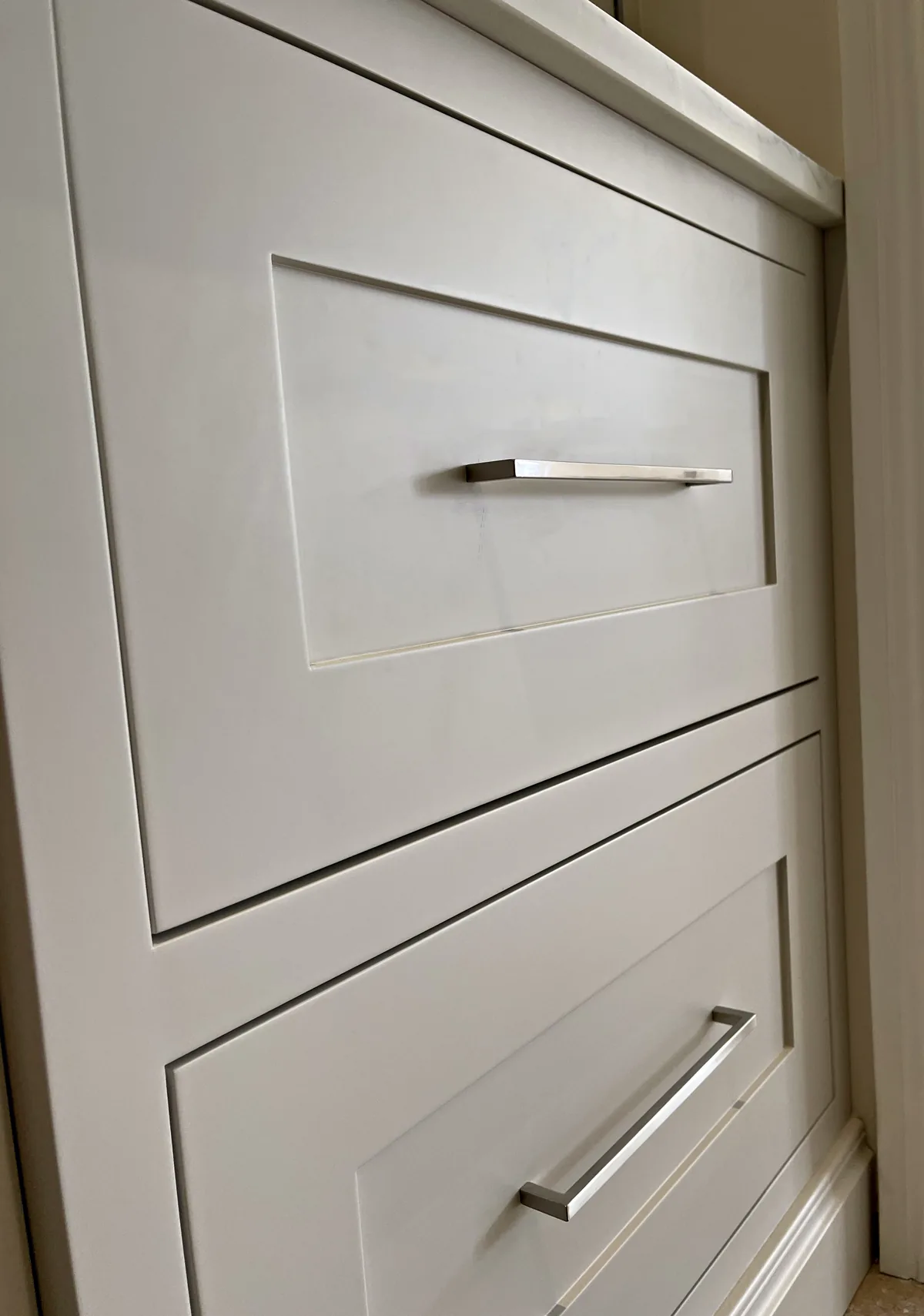 Pale painted drawers with satin chrome bar handles