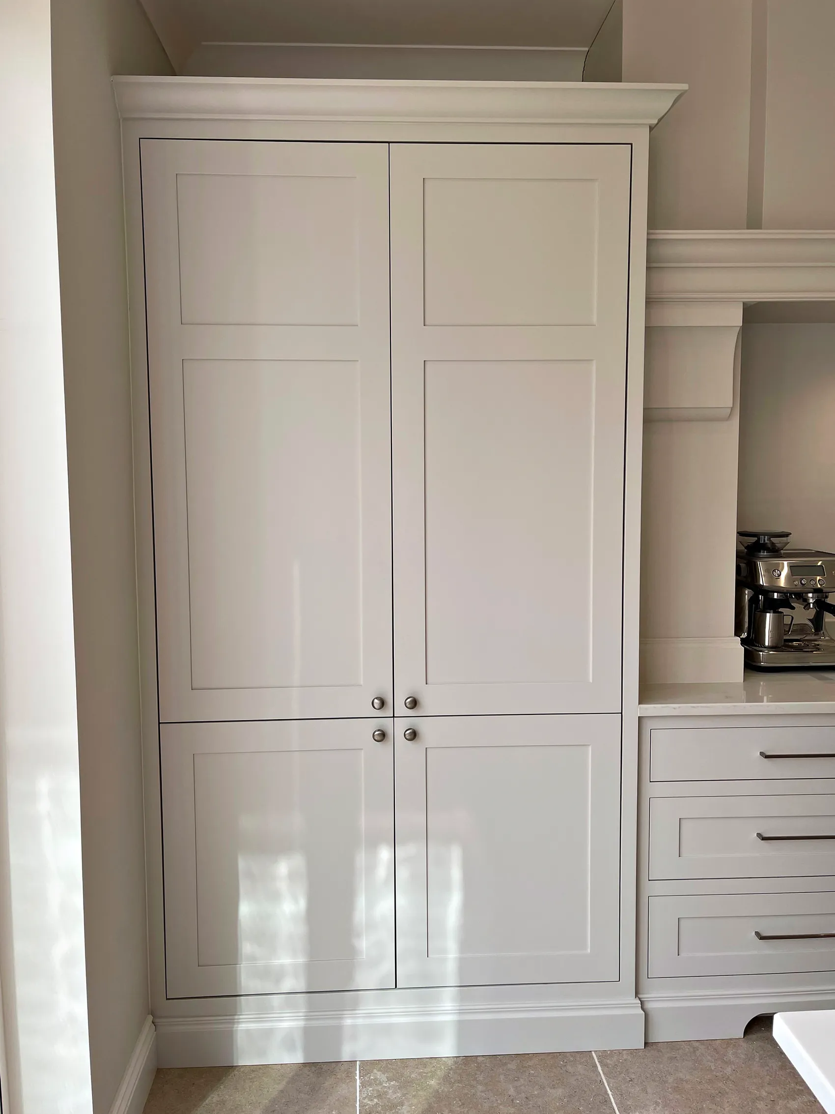 Tall painted fridge cabinet with panelled doors