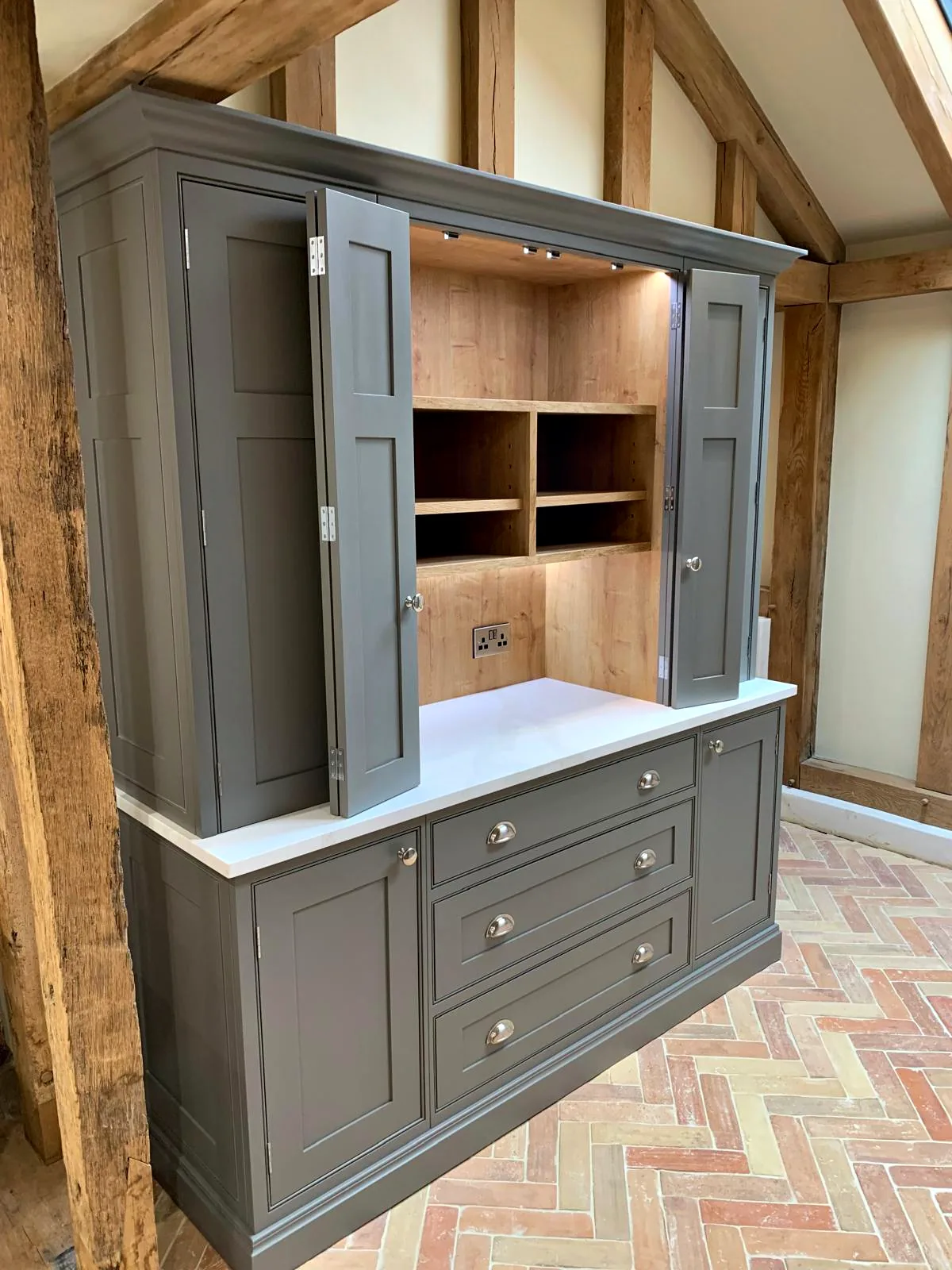 Dark taupe dresser larder with bifold doors open on an oak lined coffee station above a bank of drawers