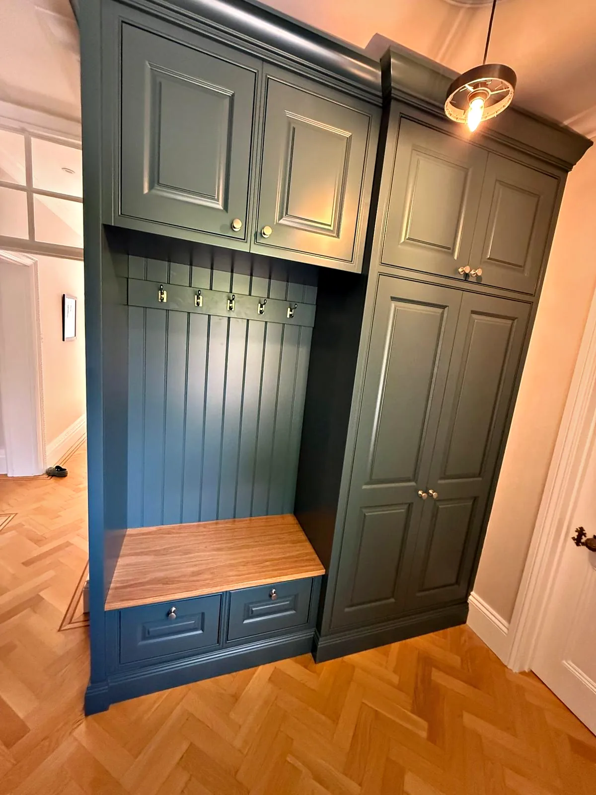 Chesham House boot room bench with an oak seat and drawers, coat hooks on tongue and groove panelling and tall cupboards either side