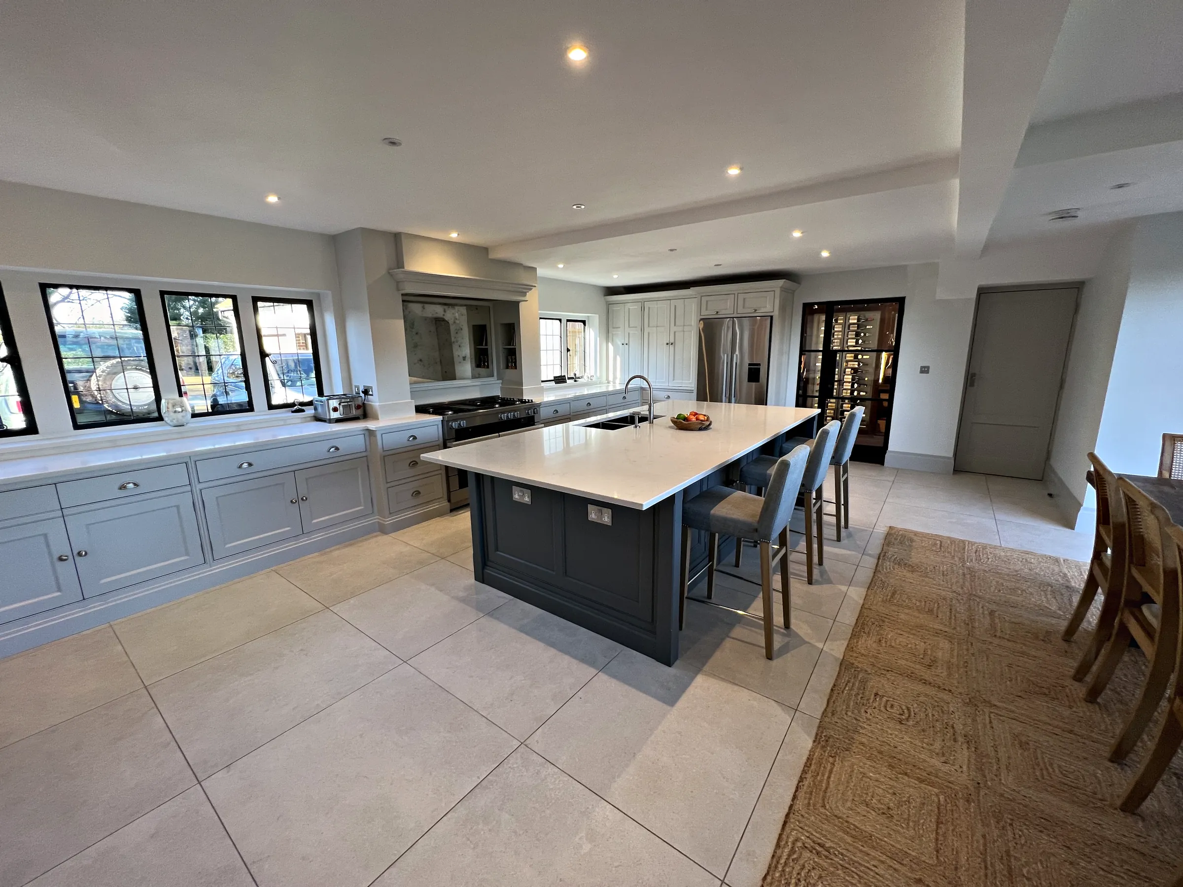 Downend kitchen with a Downpipe island and bar stools in front of the Pavilion Grey wall run and range