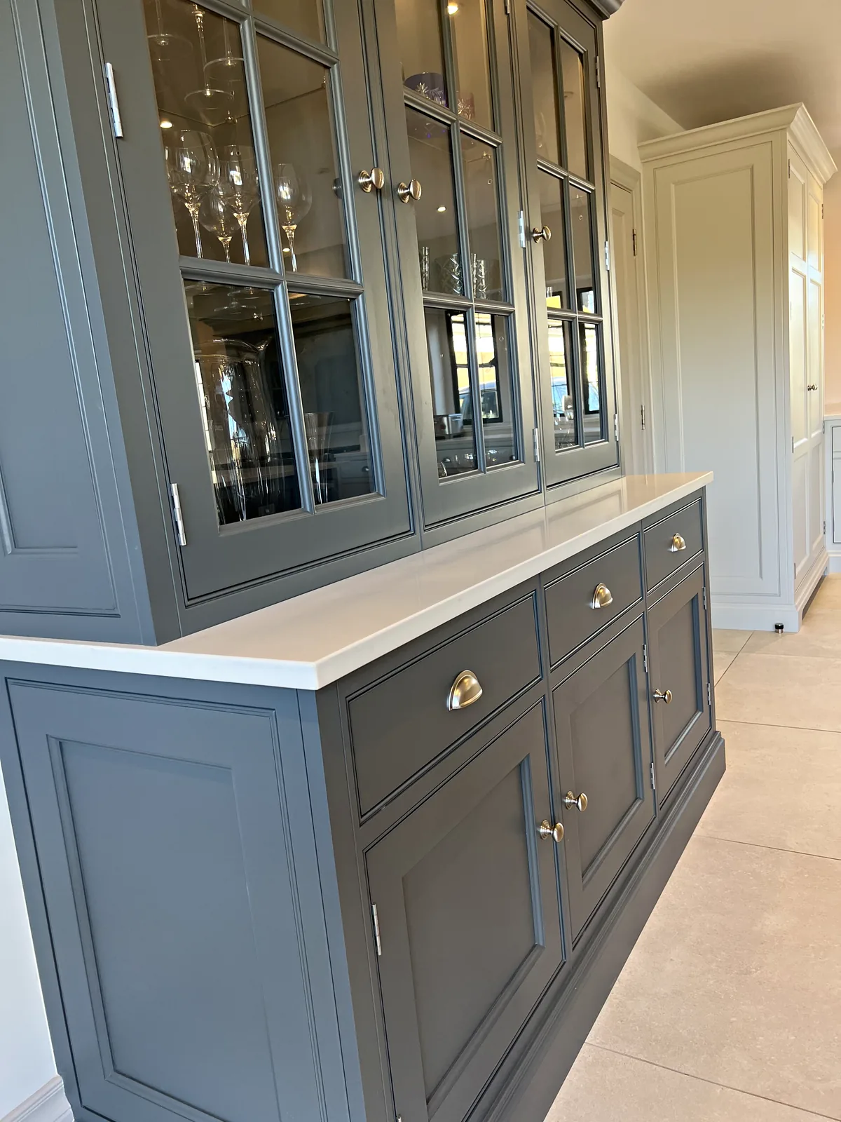 Slate grey glazed dresser with cup handled drawers beneath a white worktop