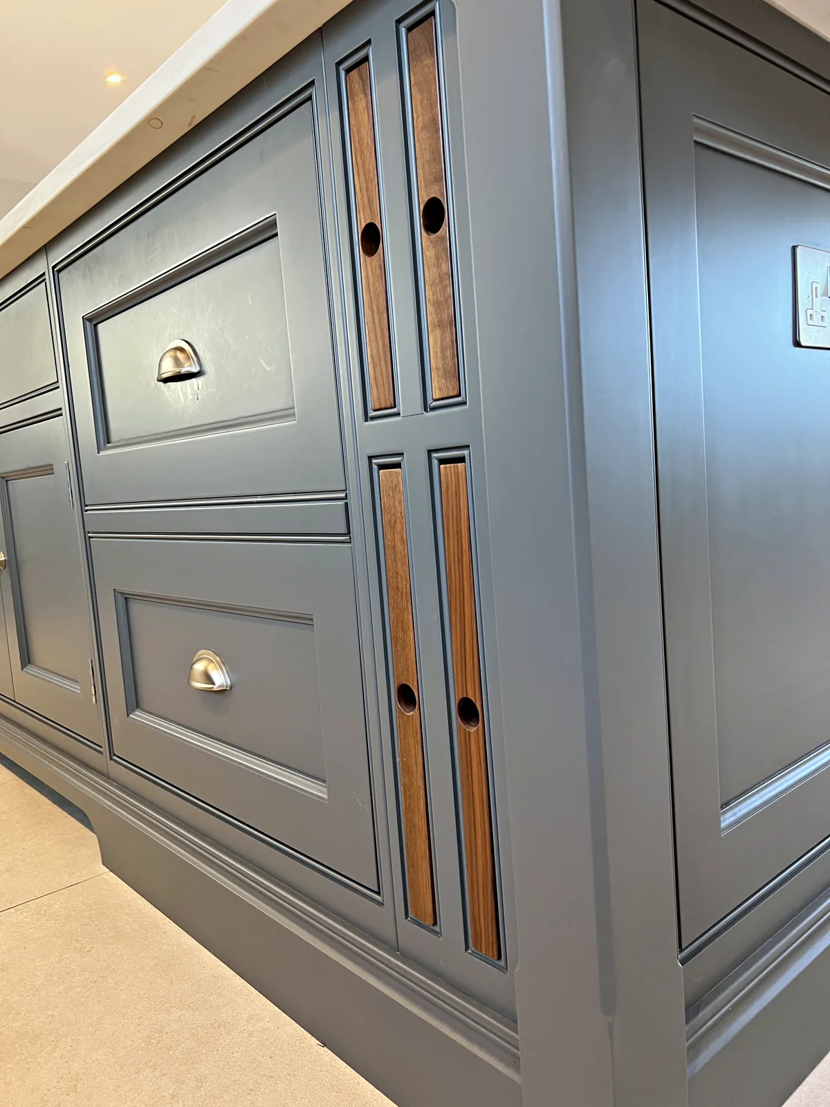Slate grey island with cup handled drawers and walnut inset panels with finger holes