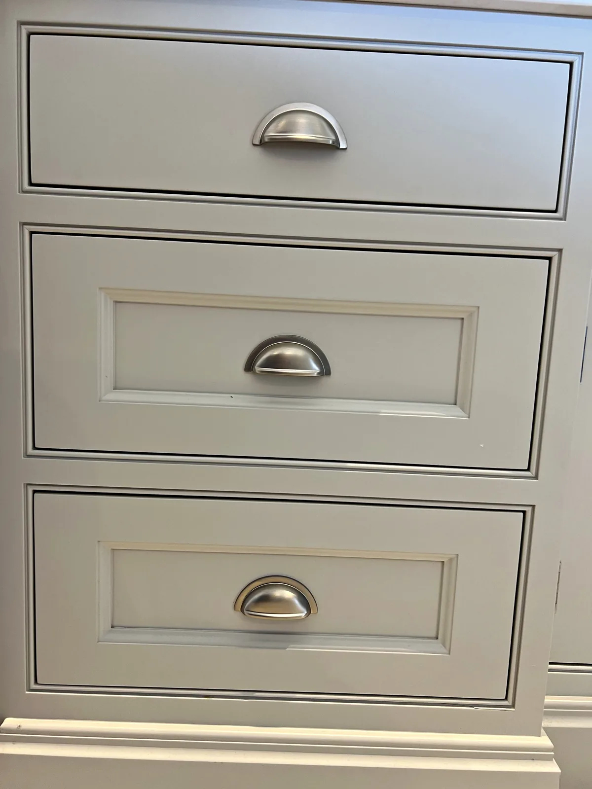 Stack of pale grey in frame drawers with nickel cup handles
