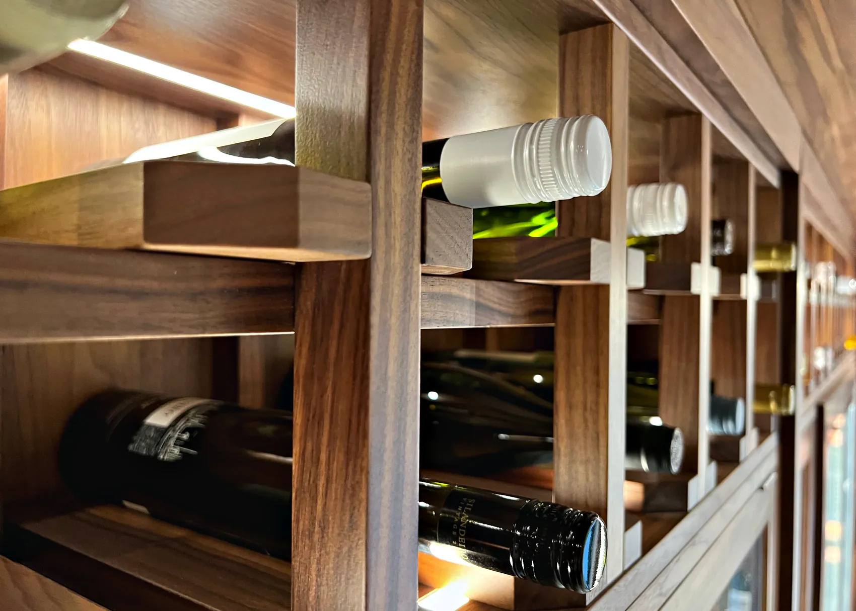 Walnut wine racks holding bottles in the Downend wine room