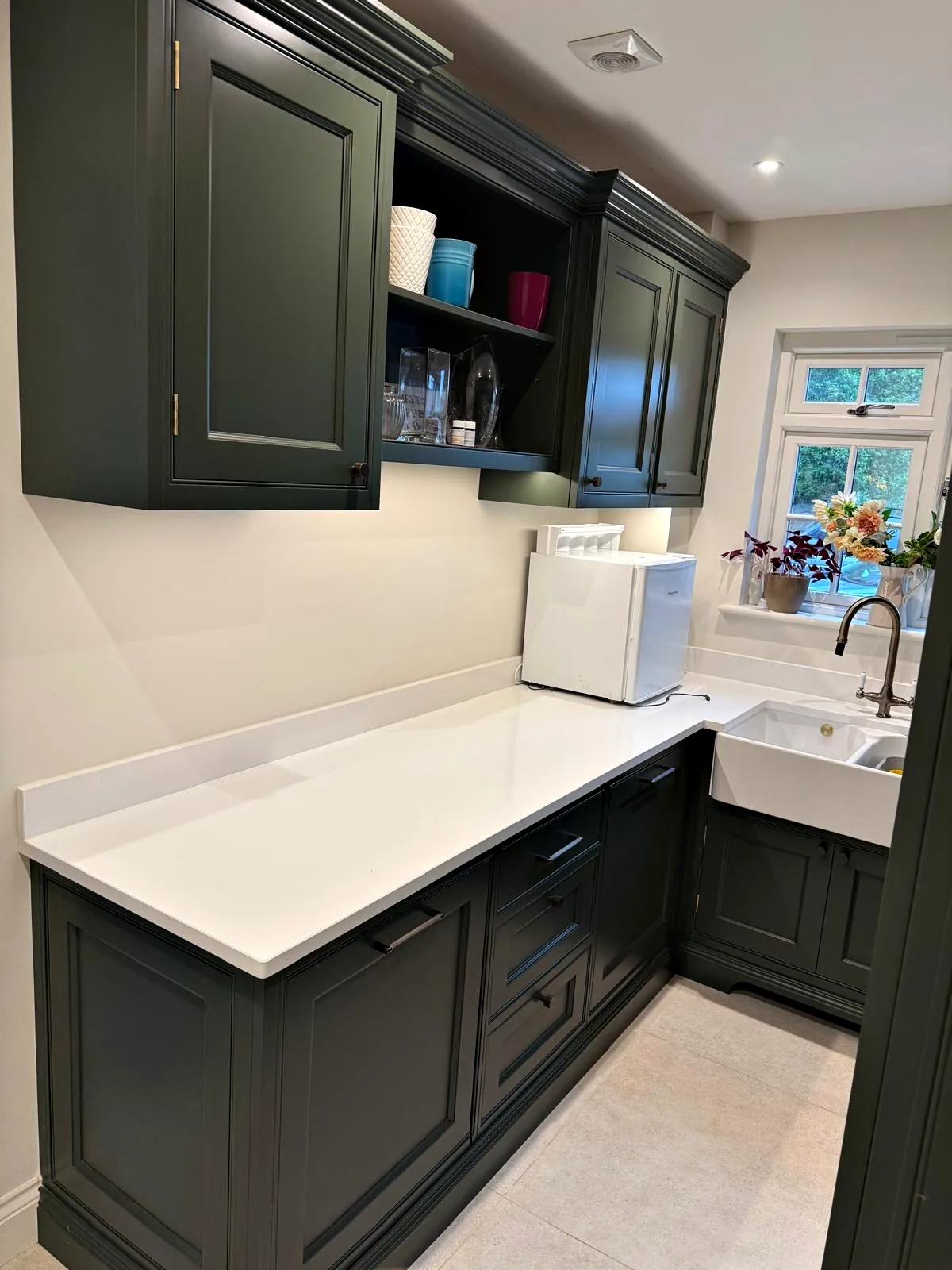 Dark green utility with a white quartz worktop, a Belfast sink and open shelves