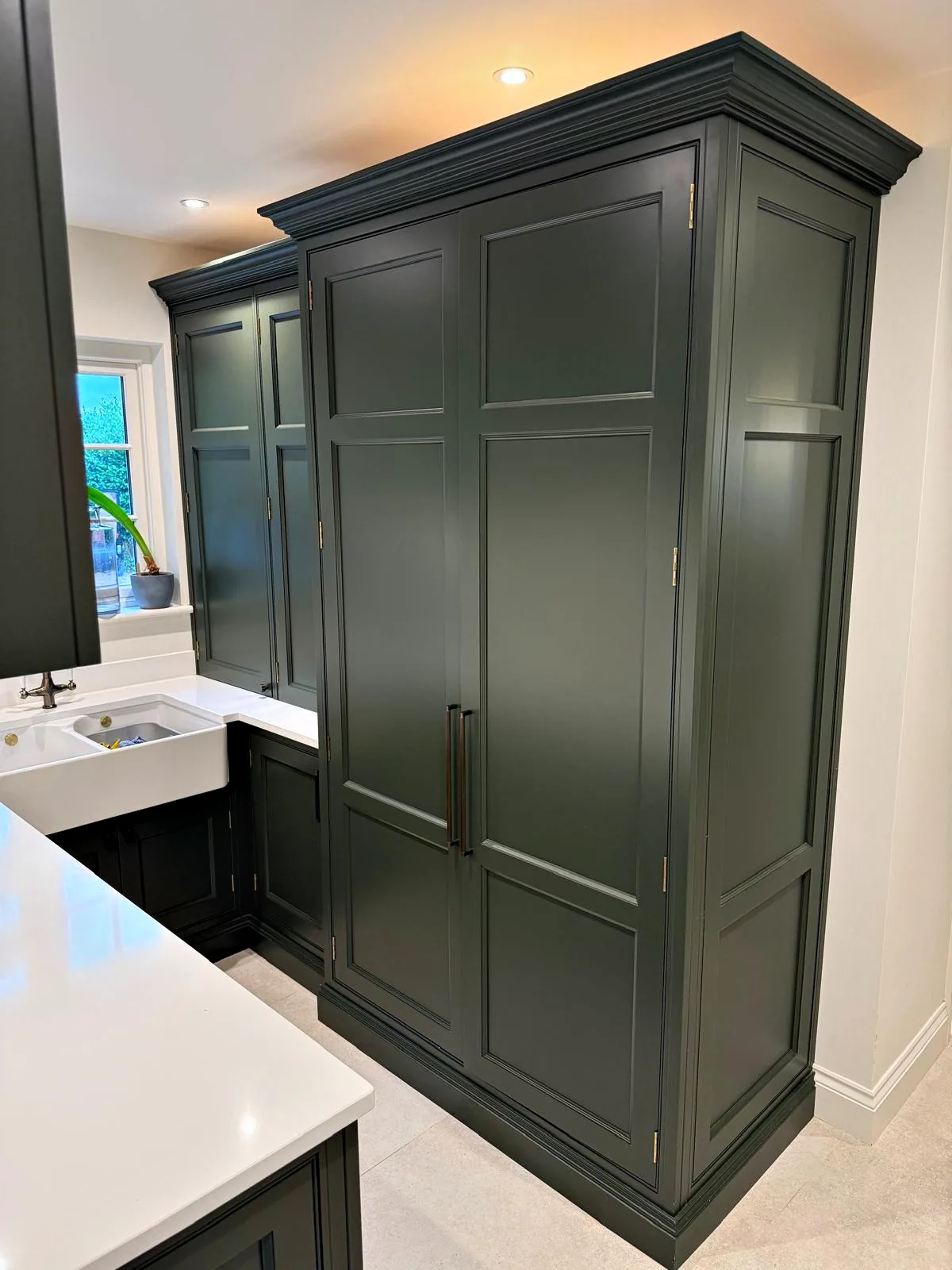 Tall dark green double larder cupboard with a crown cornice