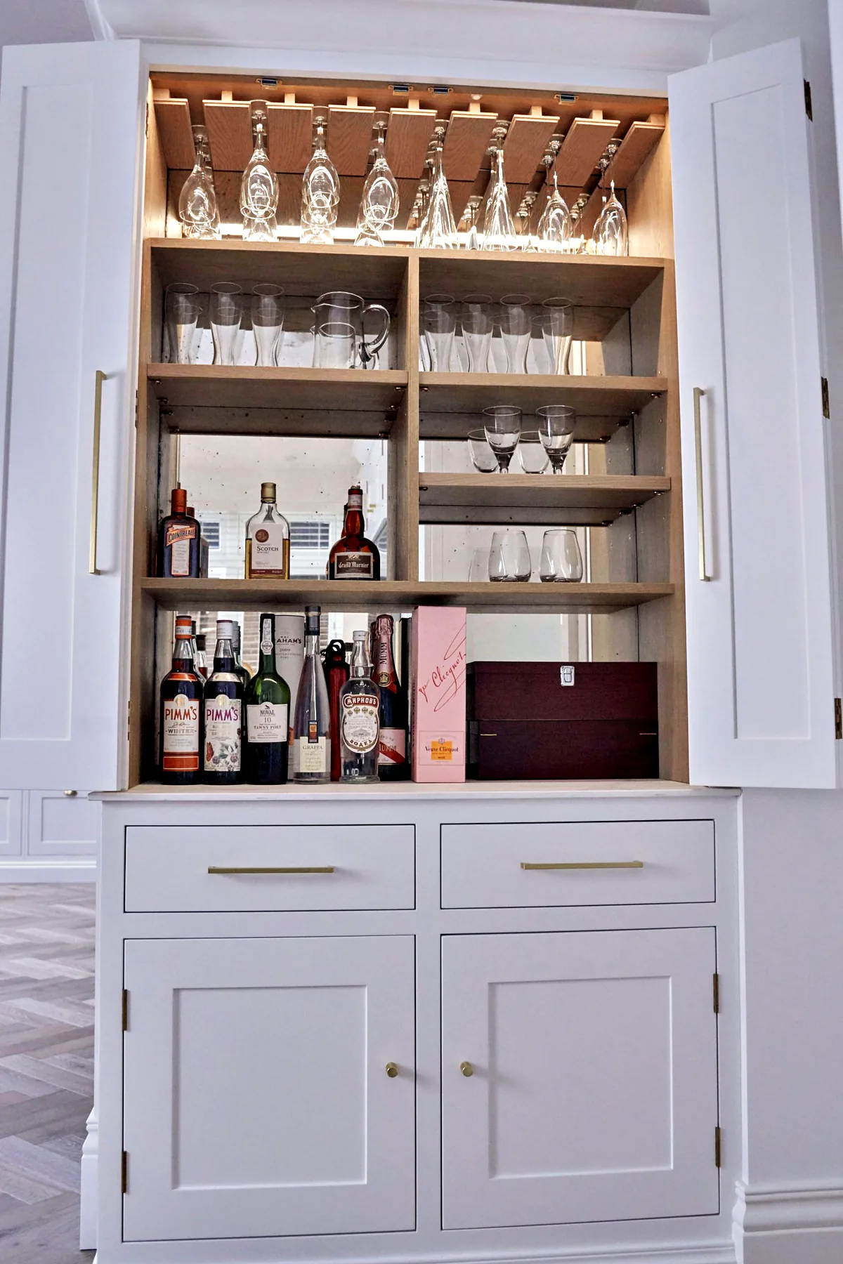 Drinks cabinet with glass shelves and a lit oak interior