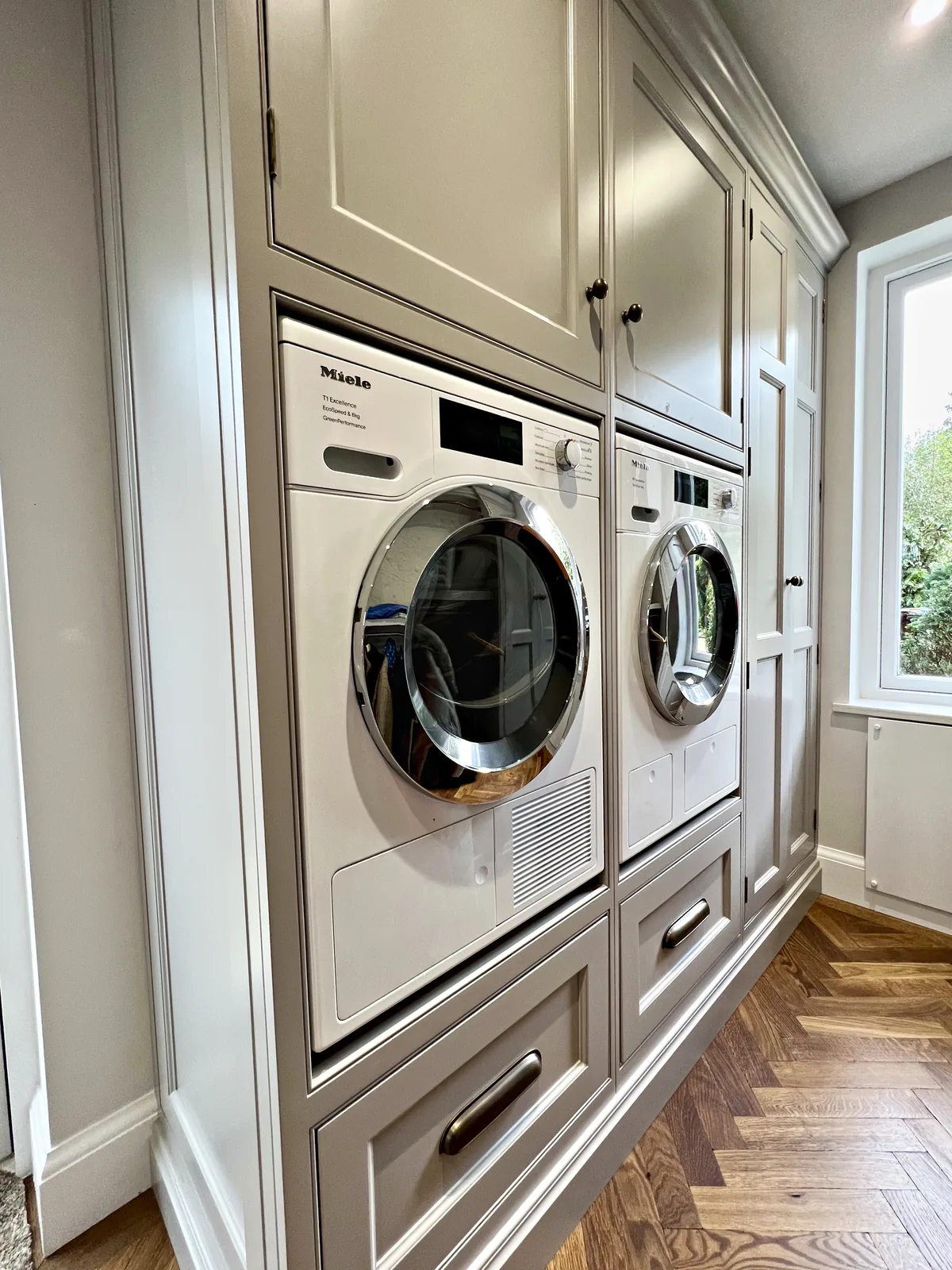 Utility room with a stacked washing machine and dryer
