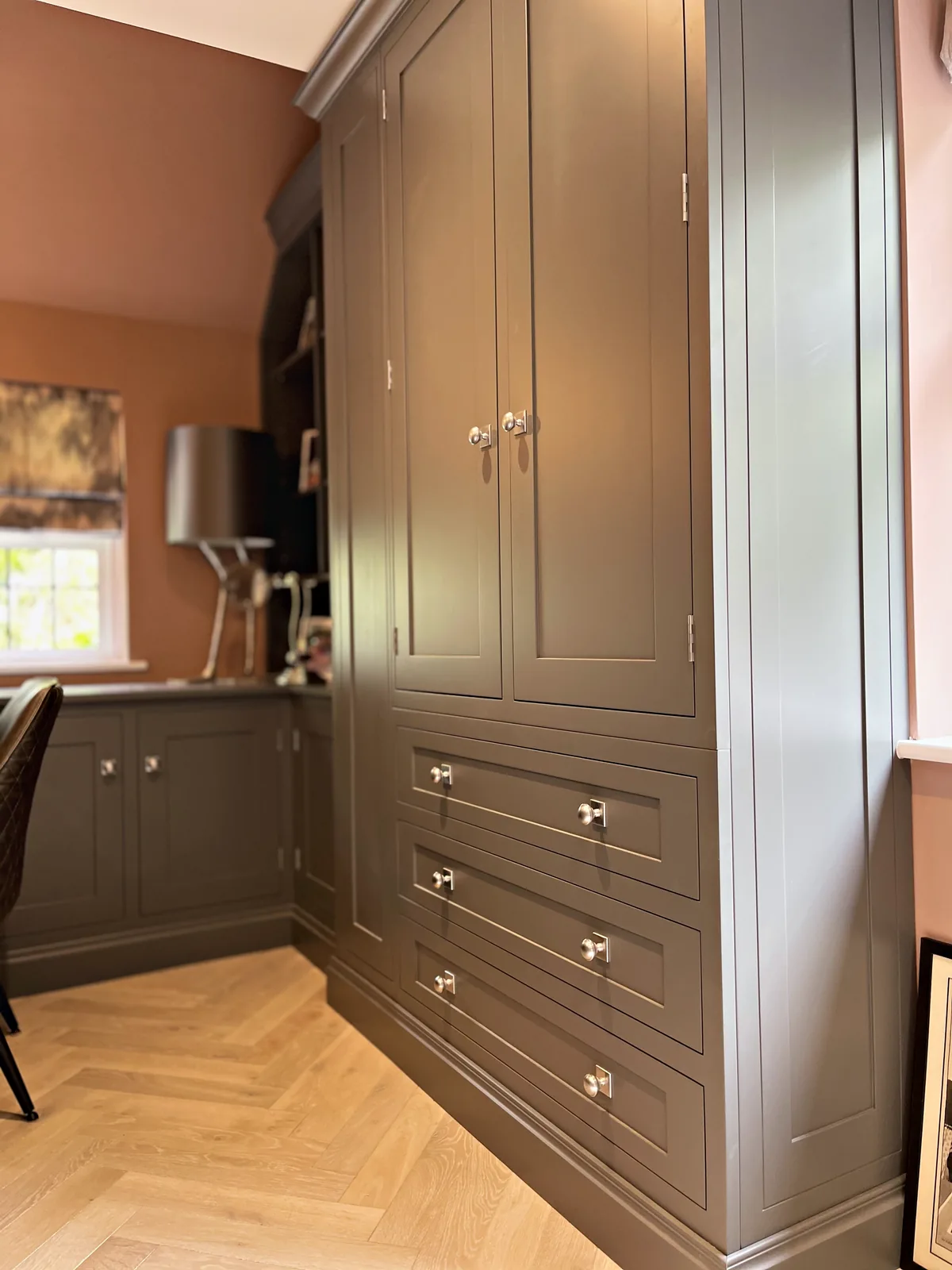 Cupboard and drawer tower with polished nickel knobs in the grey green study