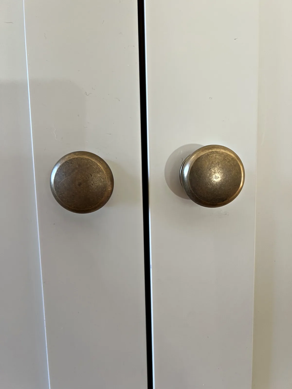 Antique brass knobs on tall cream doors