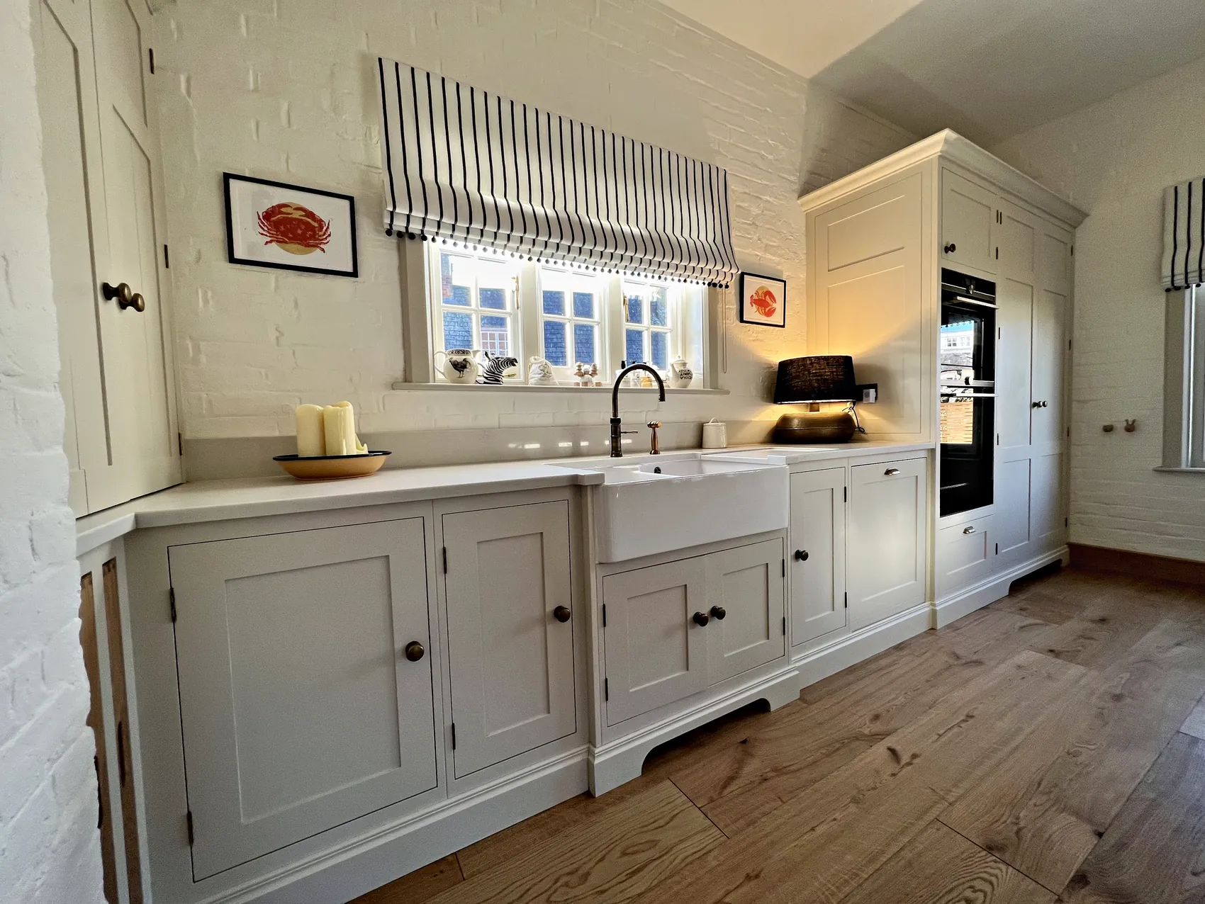Belfast sink run with a bronze tap beside the tall oven housing