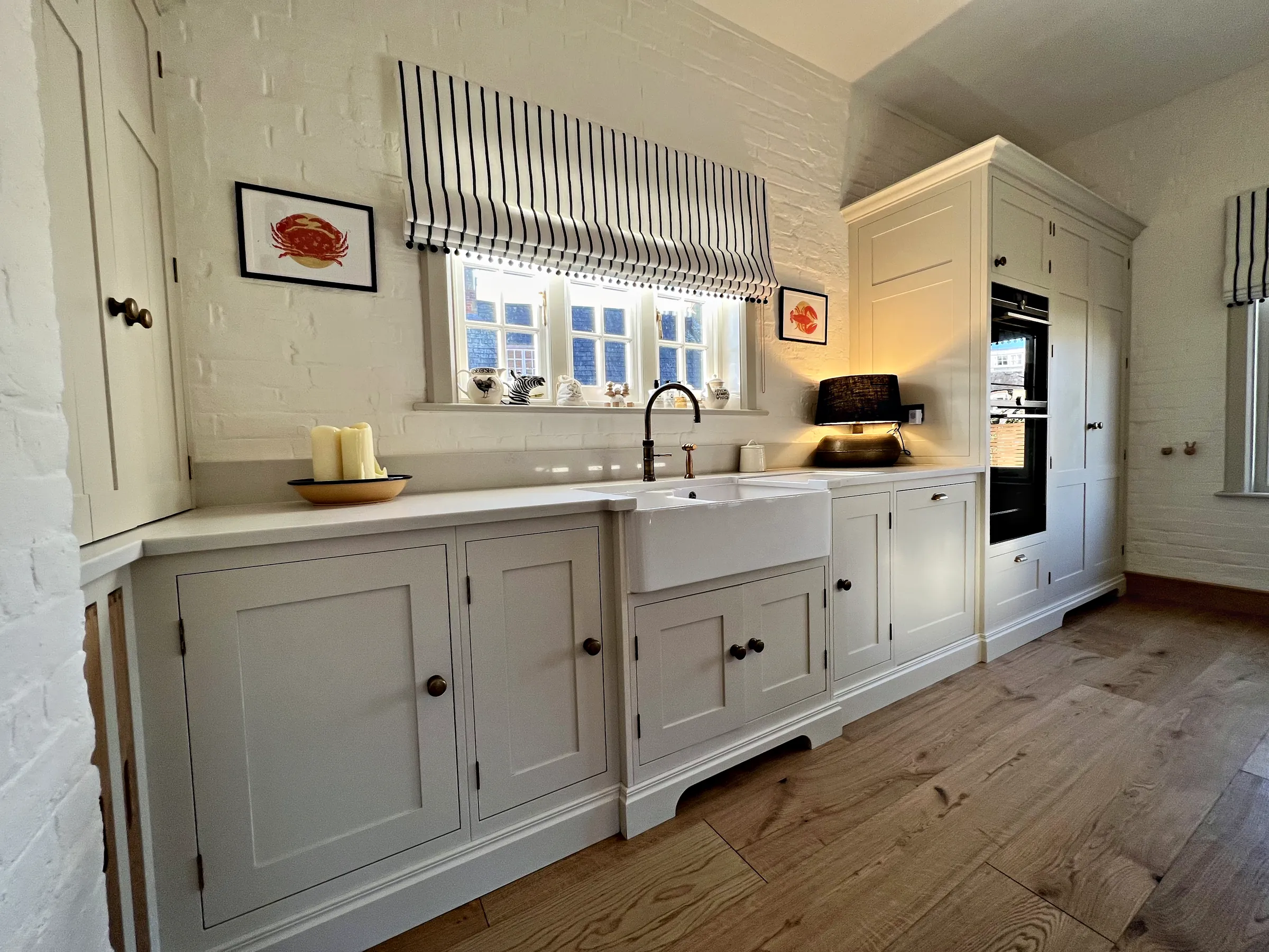Belfast sink run with a bronze tap beside the tall oven housing