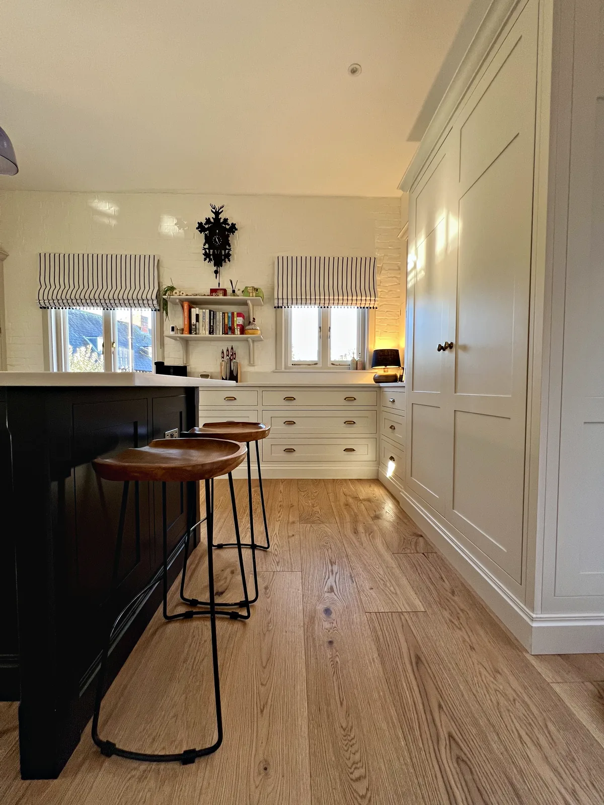 End of the Plimsoll island with stools and panelled cabinetry