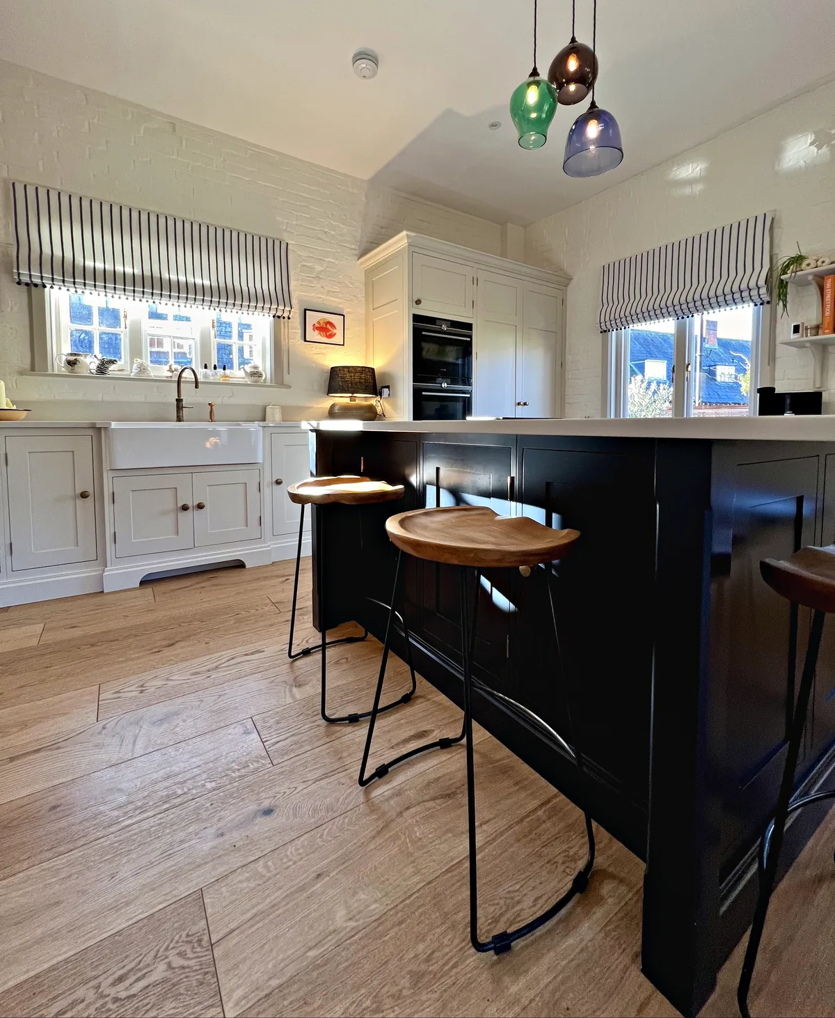 Plimsoll island with stools and a glazed dresser beyond