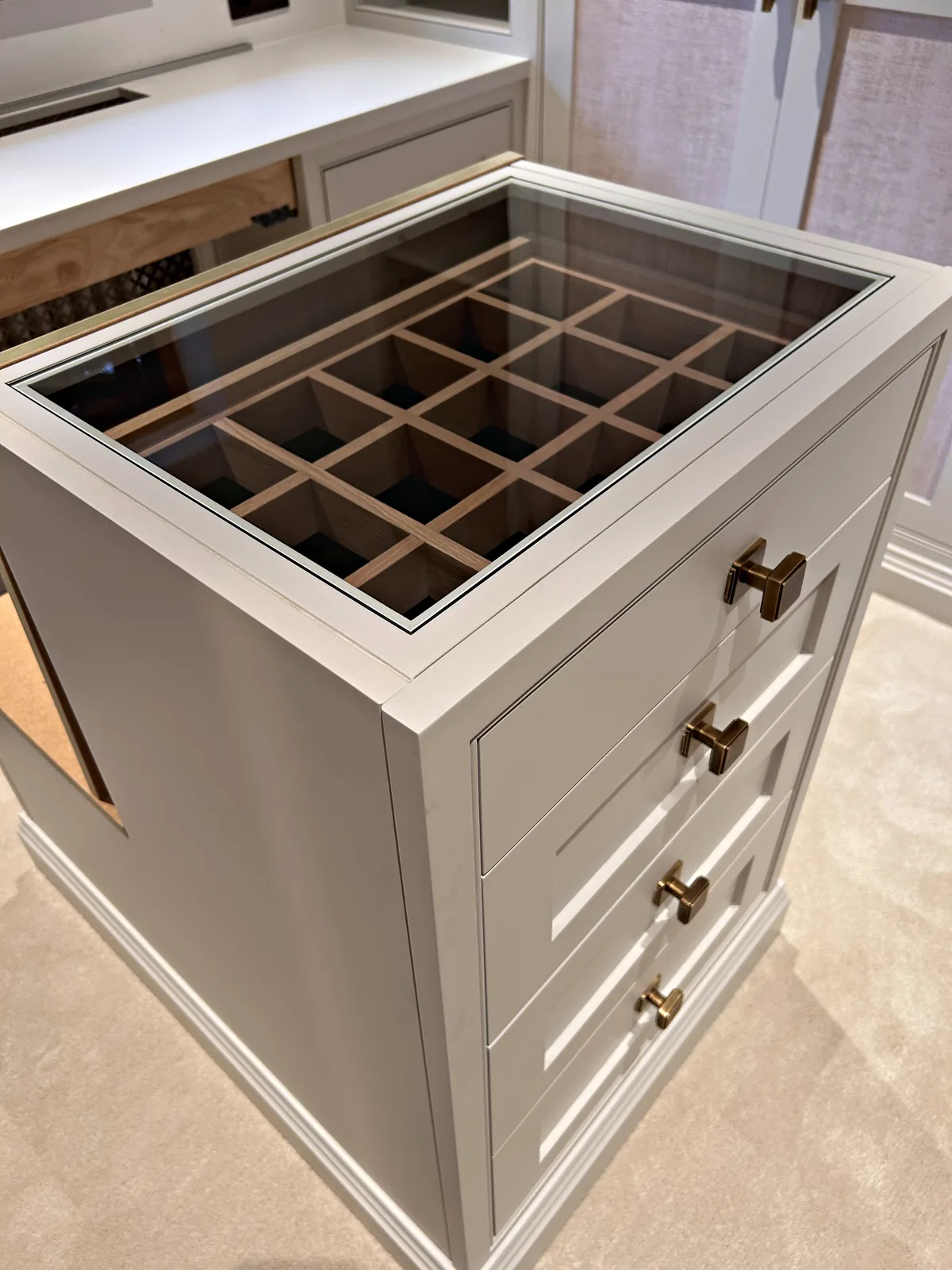 Dressing island with a glass topped jewellery tray over drawers with bronze knobs