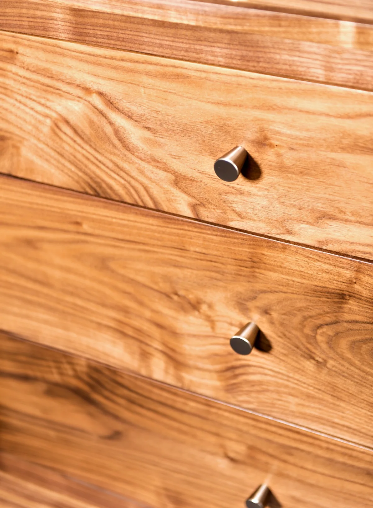 Figured walnut drawer fronts with small round nickel knobs