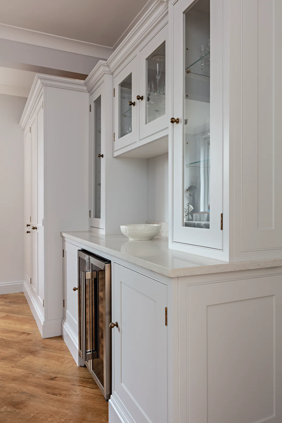 Pale painted dresser with glazed wall cabinets, a wine cooler and brass knobs